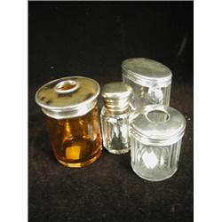 A silver lidded and glass hair tidy, one other with a silver and tortoiseshell lid, an oval silve...
