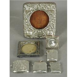 A silver mounted watch holder 1903, two small silver mounted photograph frames and four silver ve...