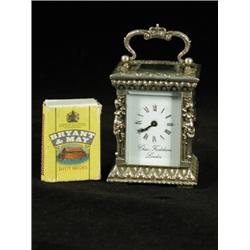 A modern miniature silver carriage clock in a cast case, the enamel dial inscribed 'Chas Frodsham...