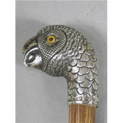 An Edwardian silver mounted parasol, the silver handle in the form of a parrot on a bamboo shaft,...
