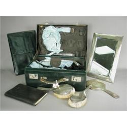 A ladies leather fitted dressing case, with silver backed brushes, hand mirror, a large silver ea...