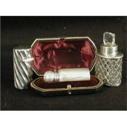Three silver scent bottles: One in a fitted case, 1900 One glass in a silver sleeve, 1914 and One...