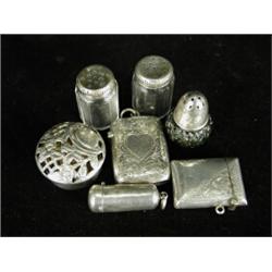 Seven silver items: Two vestas Four scent bottles and a cylindrical box with a pierced cover Est....