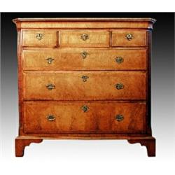 A late George II walnut and feather banded chest, canted fluted corners flanking three short and