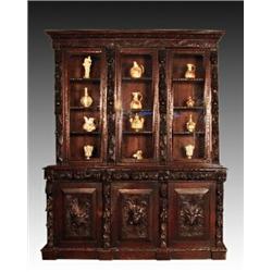 A late Victorian carved oak bookcase, circa 1900, with stepped cornice and scroll carved frieze a