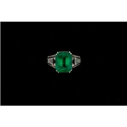 RING: [1] Ladies platinum, emerald and dia. Center emerald is rectangular step cut measuring 11.95mm