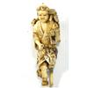 Image 1 : Carved ivory Netsuke modelled as a young man with pegleg carrying a bucket of leaves on his back,…