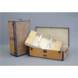 A matching pair of Louis Vuitton trunks, with studded tan leather bound orange canvas, opening to...