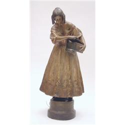 A large Goldscheider plaster figure of Pandora's Box modelled as a lady in gold pleated dress hol...