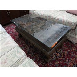 Heavily carved Oriental table with a glass top