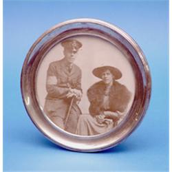 A George V circular silver photo frame, 7ins. £80-120...