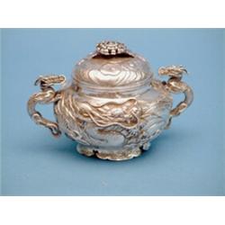 A Chinese white metal sugar bowl and cover, with chrysanthemum knop and dragon handles £800-1,200...