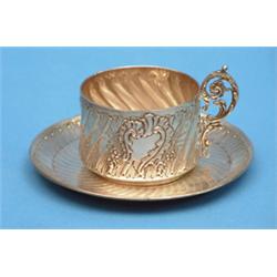 A French silver tea cup and saucer, with spiral fluting and foliate scroll decoration £100-150...