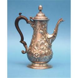 A George III silver coffee pot, of baluster form with ebonised handle and rococco scroll decorati...