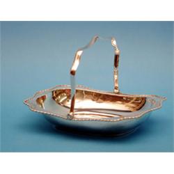 A George V silver cake basket, of serpentine rectangular form with swing handle 10ins £250-300...