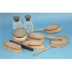 A Asprey & Co. 9-piece dressing table set, with engine-turned silver mounts with parcel gilt flor...