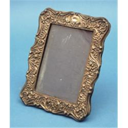 An Edwardian silver mounted photo frame, with foliate scroll decoration 7.5ins £100-150...