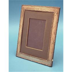 A George V silver mounted photo frame, with ribbon tied reeded border 10ins £150-200...