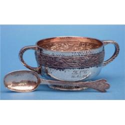 A George V hammered silver porringer, with celtic border and matching spoon £120-150...