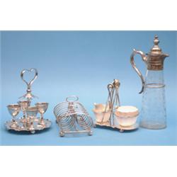 A plated egg cruet, a sugar and cream set and a claret jug £120-180...