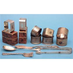 Eight assorted silver napkin rings, a pair of tongs and 3 other items £100-120...