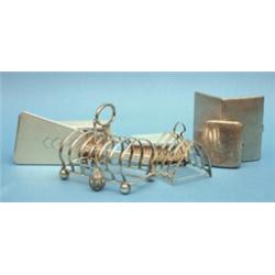A group of associated silver ware, including 2 toastracks, a Russian spoon and a brush set £150-2...