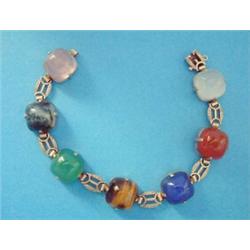 A 9ct gold bracelet, set seven multi coloured cabochon specimen hardstones £70-100...