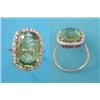 Image 1 : A gold dress ring, claw set with an oval faceted peridot, in a border of diamonds (peridot approx...