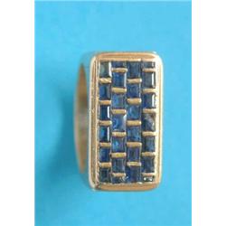 A modern yellow metal dress ring, the rectangular bezel set calibre cut sapphires £100-150...