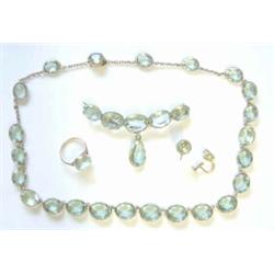 A suite of gold mounted faceted blue paste jewellery, comprising a riviere necklace, a crescent b...