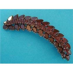 A late Victorian curved leaf shaped brooch, set flat cut garnets £70-100...