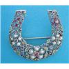 Image 1 : A gold openwork horseshoe shaped brooch, set rubies, sapphires, demantoid garnets and split pearl...