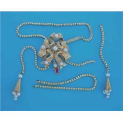 A gold snake link necklet, with seed pearl tassel drops having a tied ribbon slide set emeralds a...