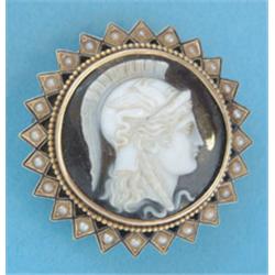 A Victorian gold circular banded agate cameo brooch carved with a classical profile within a blac...
