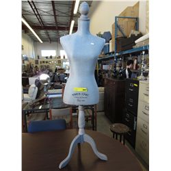 Female torso form on stand.