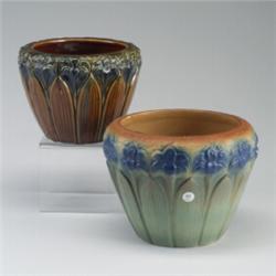 Two BRUSH MCCOY jardinieres embossed with lilies, one in glossy blue and amber, the other in matt...