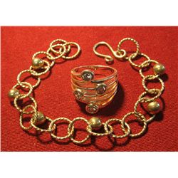 825. 2 pieces of unmarked jewelry – both look like silver. Ring has white stones. Weighs 15 grams