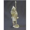 Image 1 : AN IVORY OKIMONO, c.1900, smiling fisherman carrying a creel and harpoon, incised decoration on t...