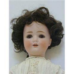 A BISQUE HEAD DOLL, brown wig, sleeping eyes, open mouth, jointed body, lawn costume, the nape ma...