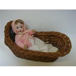 A BISQUE HEAD BABY DOLL, fawn wig, sleeping eyes, open mouth, voice mechanism, jointed limbs, nap...