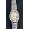 Image 1 : A Swiss lady's diamond oval bracelet watch, circa 1960, the textured silvered dial with baton num...
