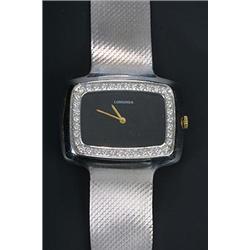 Longines, a lady's 18ct white gold oblong bracelet watch, circa 1970, the black dial with gold ba...