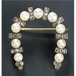 A late Victorian pearl and diamond horseshoe shaped brooch, each bouton pearl spaced by a rose di...