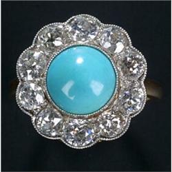 An early 20th century turquoise and diamond cluster ring, centred with a round cabochon turquoise...