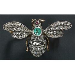 A late Victorian 'Bee' brooch, with pave set rose diamond wings and thorax, emerald body and a ru...