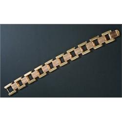 An 18ct bi-colour gold bracelet, geometrically designed as a central band of rose gold bevelled b...