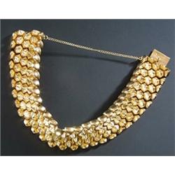 An 18ct gold broad bracelet, designed as a honeycomb of fluted bosses with plain borders, stamped...