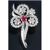 Image 1 : A ruby and diamond brooch in the form of a stylised flower centred with an oval mixed-cut ruby wi...