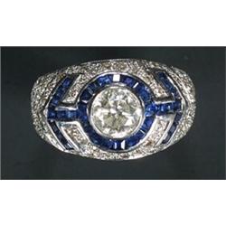 A sapphire and diamond bombe ring, the central diamond collet approx. 0.75cts within a pave diamo...