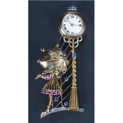 A sapphire and ruby fob watch brooch in the form a girl an a hoop dress holding and umbrella and...